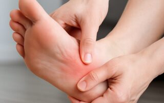 Person holding their heel due to pain, common symptom treated by foot specialists in Canton, MI. Canton Podiatry.